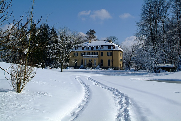 Zwei Spuren im Schnee führen durch den Queen-Auguste-Victoria-Park zum Schloss